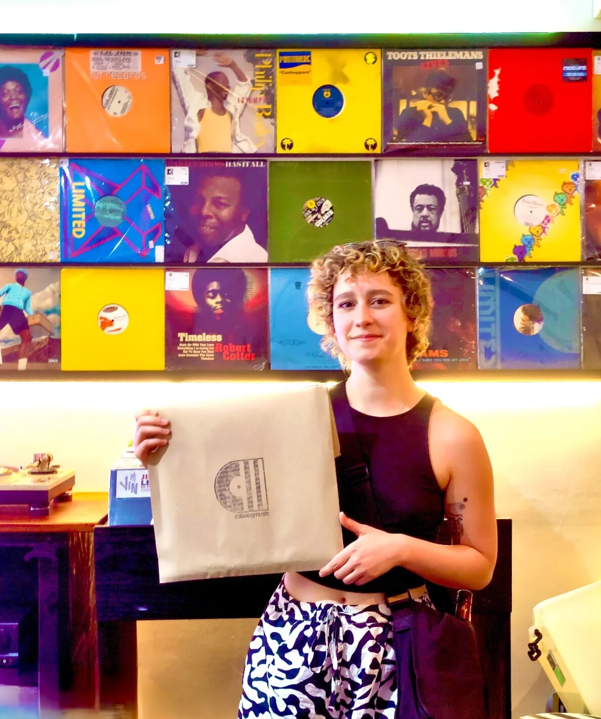 customer with catalog tote, curly hair